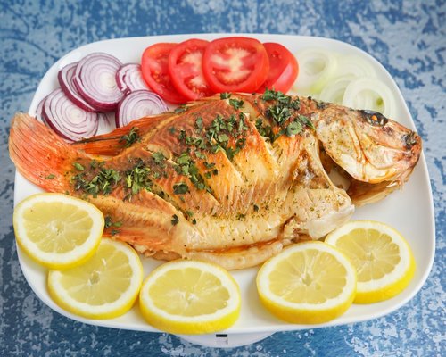 Home-cooked fish seasoned with olive oil and green herbs
